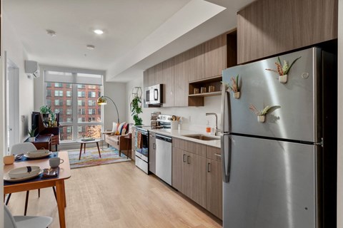 a kitchen and living room with a refrigerator and a table